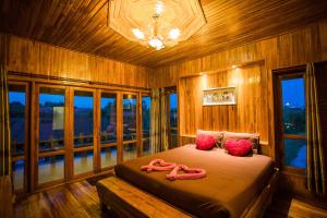 una camera da letto con un grande letto con cuscini rosa di Tarahill Khao Kho a Khao Kho