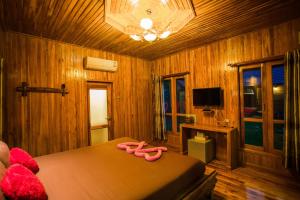 a bedroom with a bed with pink slippers on it at Tarahill Khao Kho in Khao Kho