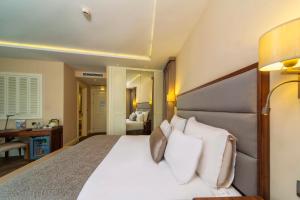 a bedroom with a large bed with white pillows at Hotel Morione & Spa Center in Istanbul