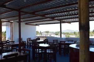 un restaurante con mesas y sillas de madera y ventanas en Paraiso de Isabela, en Puerto Villamil