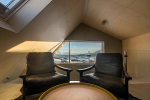 zwei schwarze Stühle in einem Zimmer mit Fenster in der Unterkunft Viking Cottages & Apartments in Akureyri + 100 Fotos