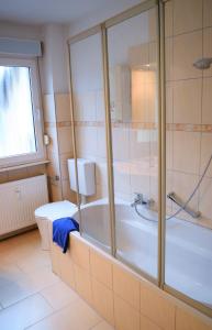 a bathroom with a tub and a toilet at Ferienwohnungen Leverkusen Schlebusch in Leverkusen