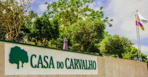 un panneau indiquant casa do cararagua à côté d'un drapeau dans l'établissement Casa do Carvalho - Ponte de Lima, à Ponte de Lima