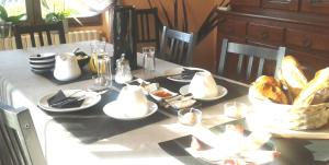 una mesa con platos de comida y una cesta de pan en Chambres d'Hôtes Selon Morphee en Selongey