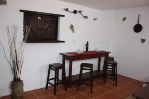a kitchen with a table and stools in a room at Casa Rural "La Molina" in Máguez