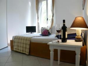 ローマにあるA Casa di Bettaのベッド1台(ワイン1本付)、テーブル(ランプ付)