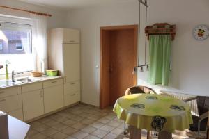 eine Küche mit einem Tisch und eine Küche mit einem Waschbecken in der Unterkunft Ferienwohnungen Akzent in Papenburg