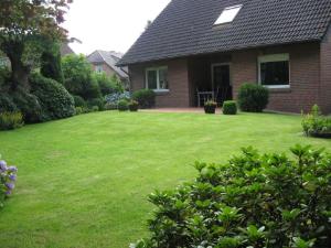 a house with a yard with a green lawn at Ferienwohnungen Akzent in Papenburg