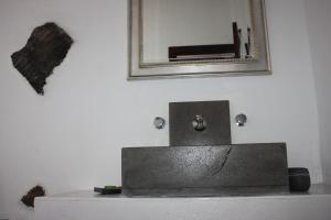 a bathroom sink with a mirror on a white wall at Casa Rural "La Molina" in Máguez