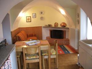 kuchnia ze stołem oraz salon z kominkiem w obiekcie Antica Casa Ortensia w mieście Riva del Garda +63 zdjęcia