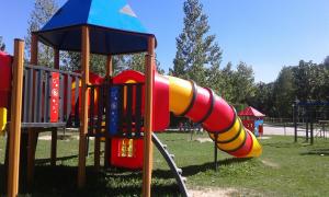 um parque infantil com um escorrega colorido num parque em Camping Pirinenc em Campdevánol