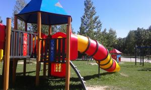 a playground with a colorful slide in a park at Camping Pirinenc in Campdevánol