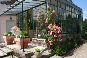 un ramo de flores en macetas frente a un edificio en Clos Saint Nicolas, en Neauphle-le-Château