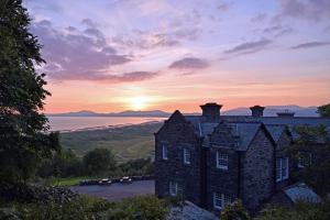 an old castle with the sunset in the background at Crown Lodge in Harlech