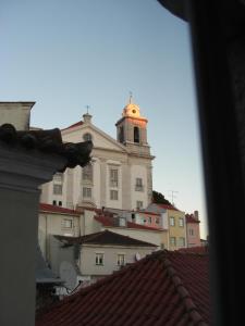 um grande edifício com uma torre de relógio no topo dos telhados em my lovely Alfama's studios em Lisboa
