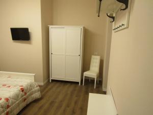 a bedroom with a bed and a cabinet and a chair at Glam Resort Giulia in La Spezia