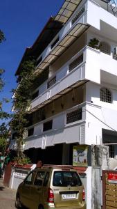 a car parked in front of a white building at i - One's Home Stay in Cochin