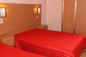 a bedroom with two beds with red sheets at Guest House Estrela in Porto