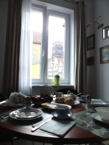 a table with plates of food on it in front of a window at Apartament MARIA in Gdańsk