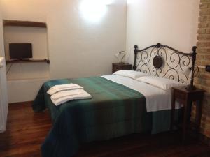 een slaapkamer met een bed met een groene en witte deken bij Casa Vacanze Sotto l'Arco in Barete