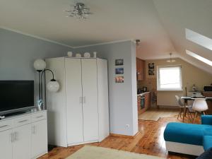 a living room with white cabinets and a tv at Noclegi Nad Małym Jeziorakiem in Iława