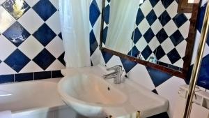 a bathroom with a sink and a mirror and a tub at Arcamyrtus in Alghero
