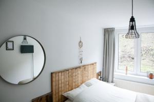 Bed & Breakfast De Plenkert في فالكنبورخ: غرفة نوم مع مرآة كبيرة وسرير