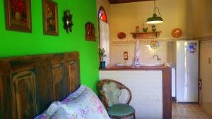 a green kitchen with a green wall and a sink at Pousada Estrela do Mar in Florianópolis