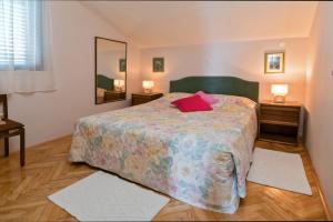 a bedroom with a large bed with a red pillow at Apartman Zlatka in Zečevo Rogozničko