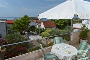 a table and chairs on a balcony with an umbrella at Apartman Zlatka in Zečevo Rogozničko