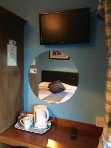 einen Spiegel an der Wand mit einem Bett in einem Zimmer in der Unterkunft Maureen's Bed and Breakfast in Tralee