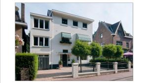 a white house with a fence in front of it at Bed & Breakfast De Plenkert in Valkenburg