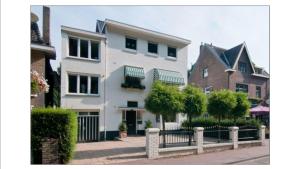een wit huis met een hek ervoor bij Bed & Breakfast De Plenkert in Valkenburg