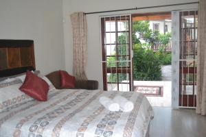 a bedroom with a bed with two towels on it at Cycad Lodge in East London