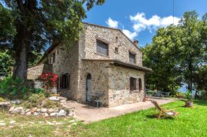 an exterior view of a stone house with a yard at Agriturismo La Collina Dei Lecci in San Gimignano