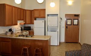 a kitchen with white appliances and wooden cabinets at Juneau Hotel in Juneau