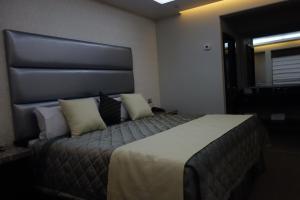 a hotel room with a large bed with pillows at Motel Marche in Mexicali