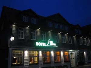 a hotel sign on the side of a building at night at Hotel Die Tanne in Goslar
