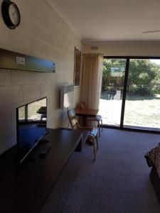 a living room with a couch and a table and chairs at Toora Lodge Motel in Toora