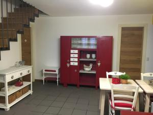 un comedor con un armario rojo y una escalera en Elleboro, en Carugo