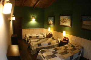 drie bedden in een kamer met groene muren bij Casa Barbadelo in Sarria