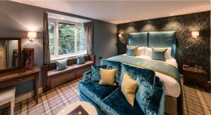 a bedroom with a large bed and a blue couch at Cedar Manor in Windermere