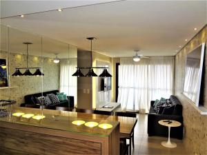 uma sala de estar com uma mesa e um sofá em Open Door Apartamentos - Maceió - Alagoas - BRA em Maceió