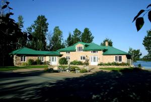 a large brick house with a green roof at Au Soleil Couchant in Val-dʼOr