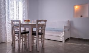 TriovasálosにあるMatilda Milos - Cycladic Livingのベッドルーム1室(ベッドの横にテーブルと椅子付)