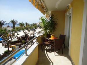 a balcony with a table and chairs and a view of the ocean at Villa Grgo Apartments in Tučepi