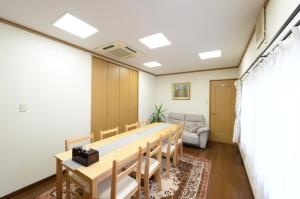 a conference room with a long table and chairs at Guesthouse Kimiko in Kasagicho