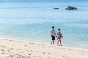 高蘭的住宿－蘭塔自然海灘度假村，海滩上行走的男人和女人