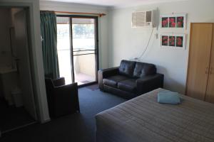 
a living room with a couch, coffee table and a television at Lake Forbes Motel in Forbes
