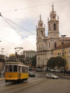 リスボンにあるApartment Estrela Heartの教会前の路面を走る黄色い路面電車